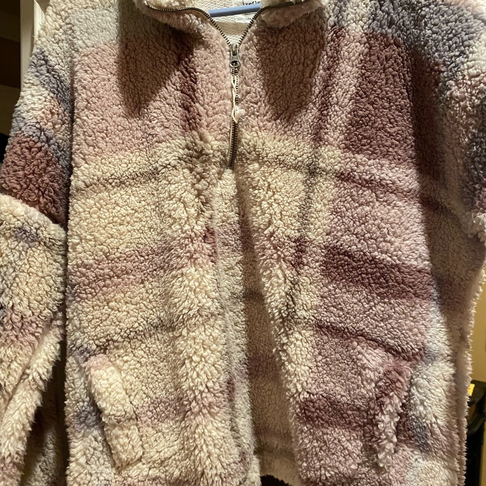 Faux Sherpa 1/2 zipper jacket with pockets. Colors are creams, mauves and grey